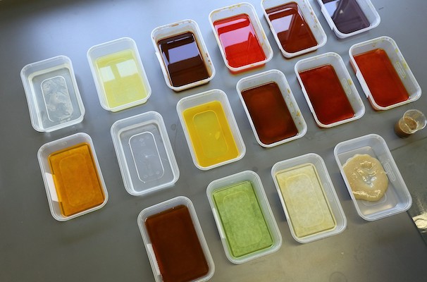 A set of 16 plastic tubs containing different shades of dye