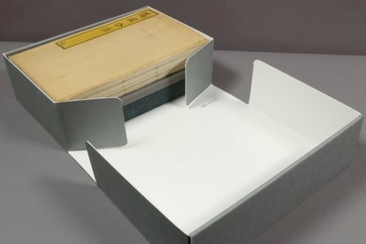 A large bound manuscript in a grey protective box