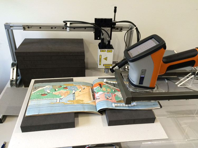 Conservation: Japanese picture book A large machine - that looks like a large camera on a stand - is positioned closed to an open picture book
