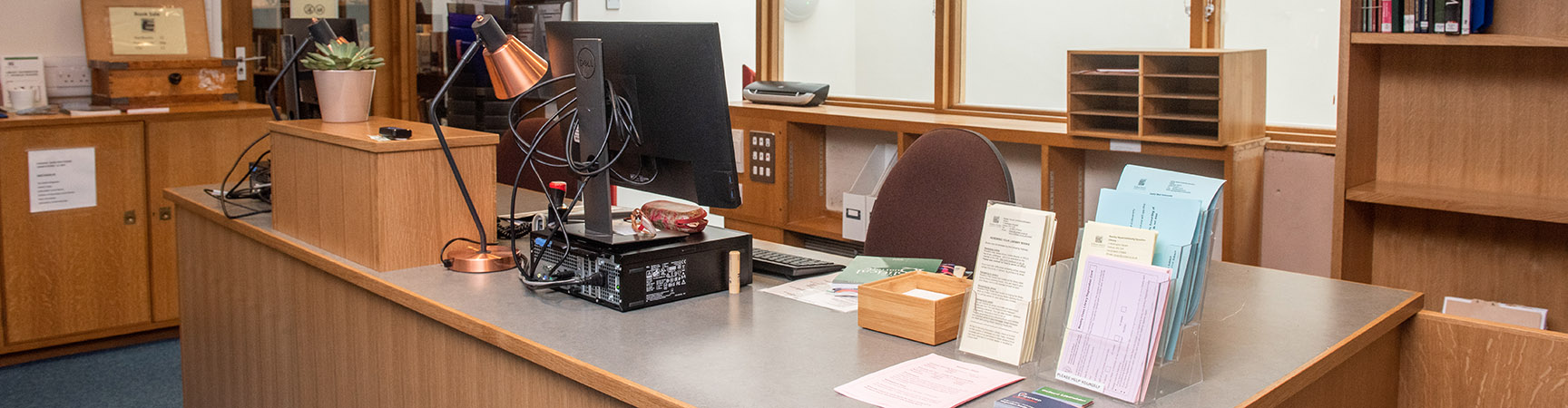 A wooden desk with a computer on it