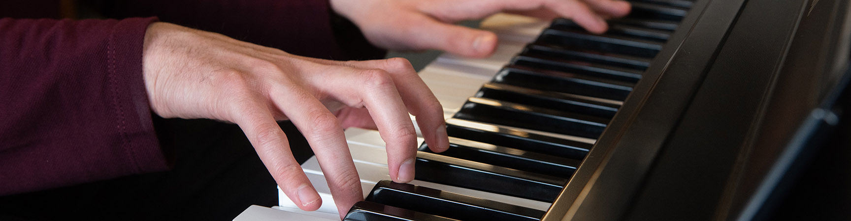 Two hands play on a keyboard