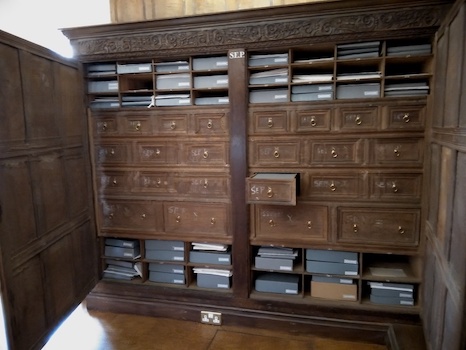 A wooden cabinet containing many drawers and files
