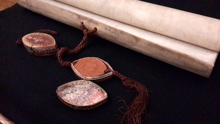 Wax seals (OUA/SW/1/1) Wax seals and a rolled scroll of parchment on a black background