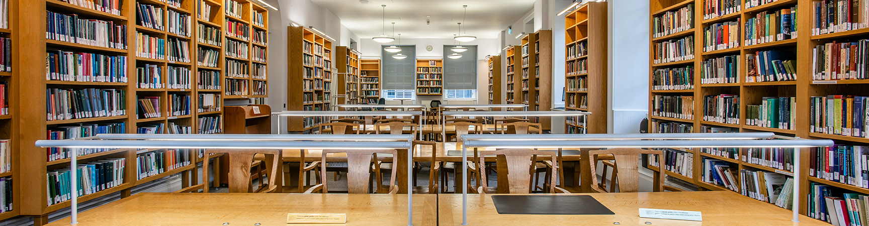 A long wooden desk across a room with bookshelves on either side