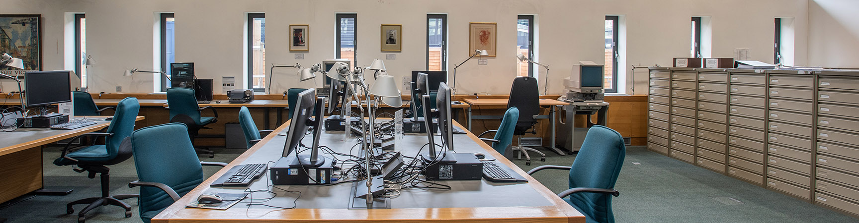 A long wide desk with desktop computers on either side
