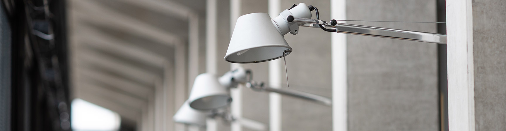 A row of grey lamps on concrete pillars