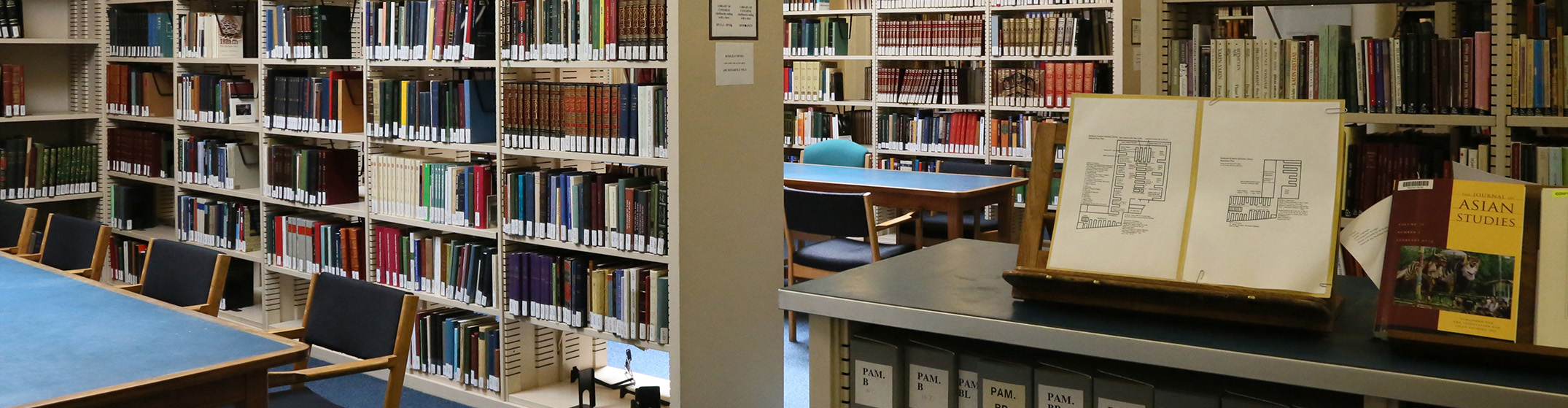 Two bookshelves with a large book open on display