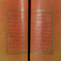 An open book with handwritten script and pages dyed yellow and pink
