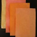 Four pieces of paper in varying shades of yellow and orange