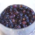 A glass jar containing dark round seeds