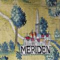A detail from the tapestry map - a small town is sewn with a church and collection of buildings - the background is bright yellow