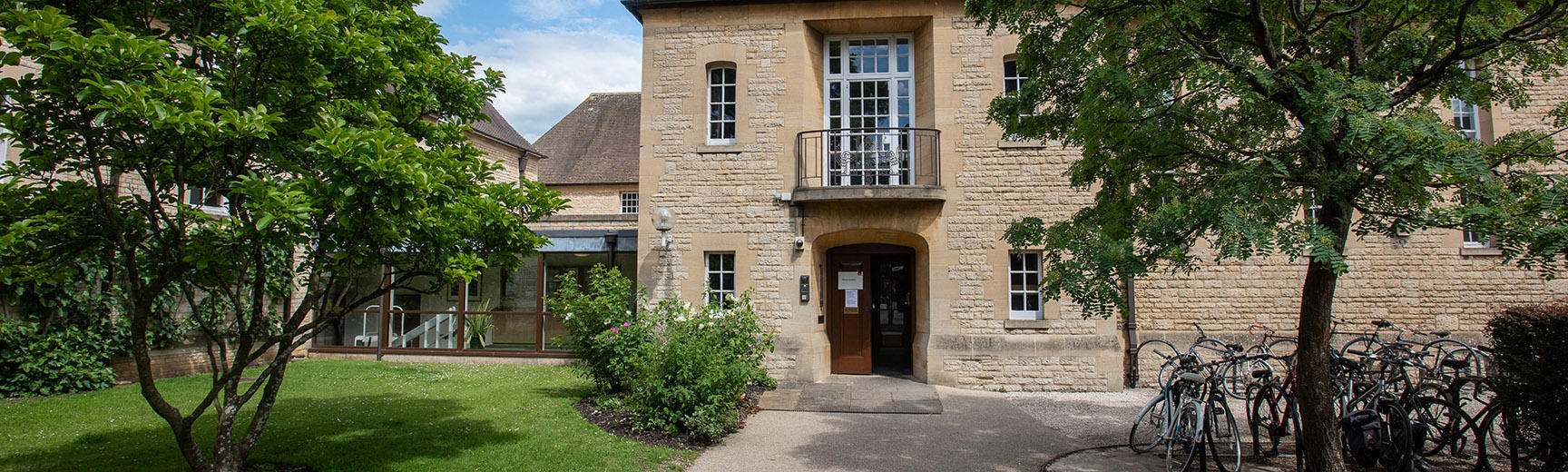 A grey building surrounded by gardens