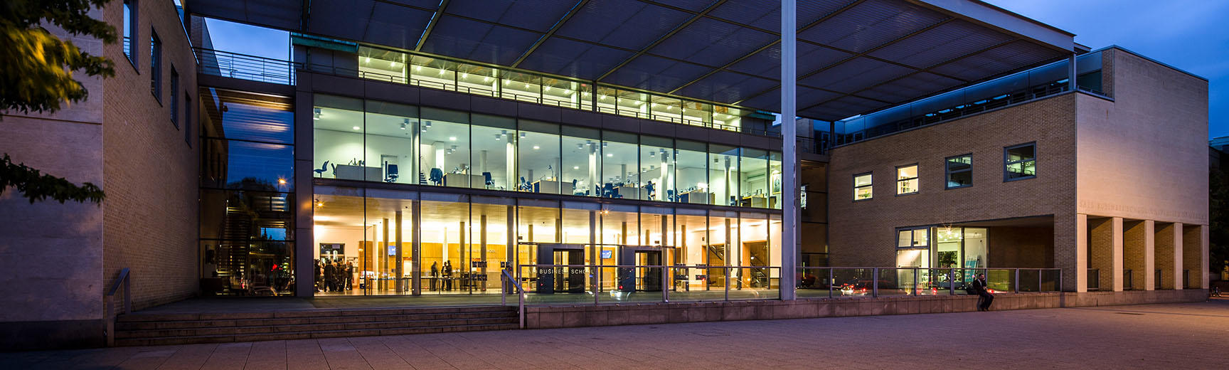 An exterior view of an illuminated glass and brick building 