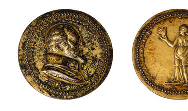 Two faces of a medal: one with an image of a man's face in profile, and the other with a woman holding two busts