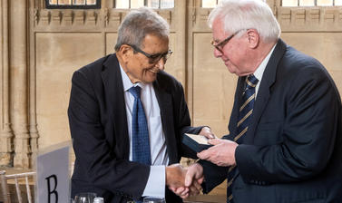 Professor Amartya Sen receives the Bodley Medal while shaking a man's hand
