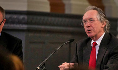 Ian McEwan sits in front of a microphone, beside Richard Ovenden