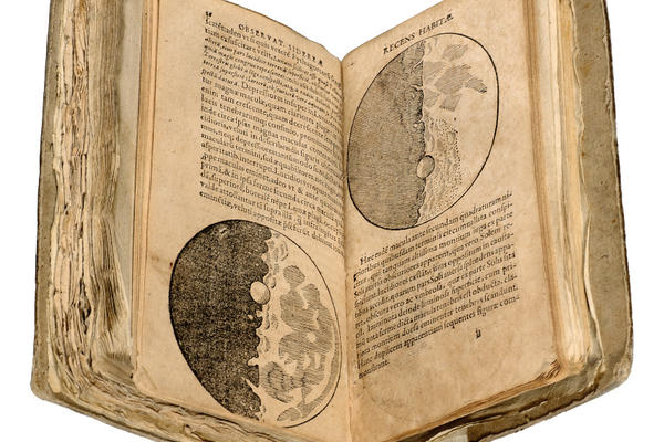 An old book open to display diagrams of the moon and text