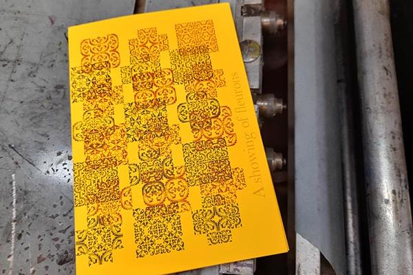 A piece of yellow paper printed with elaborate fleurons