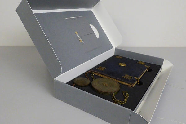 A grey display box containing seals and a book