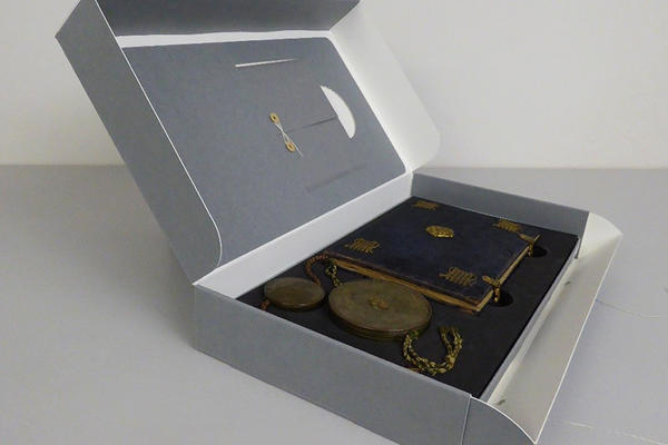 OUA/WPβ/I/1 A grey display box containing seals and a book
