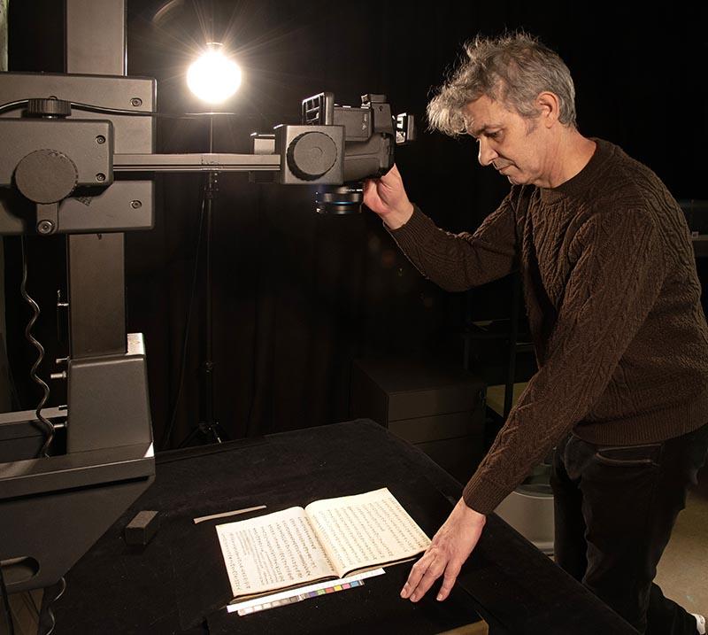 Giorgio Garippa A man uses an overhead camera to photograph a book in Chinese