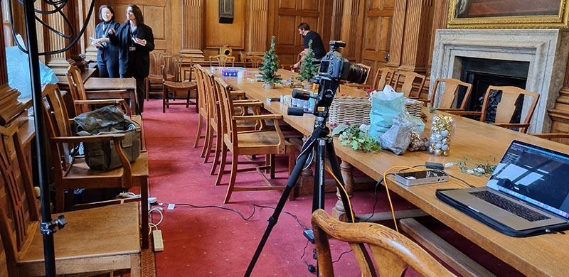 Nick Emm Cameras and gift products stand on a long wooden table, beside a laptop