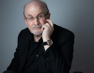 A photograph of Salman Rushdie, dressed in black