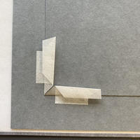 A piece of paper folded into a right angle and fixed with gummed Japanese hinging paper 