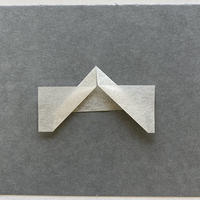 A piece of paper with tabs folded outward leaving a margin to hold the item