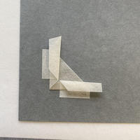 A piece of paper folded into a right angle and fixed with gummed Japanese hinging paper 